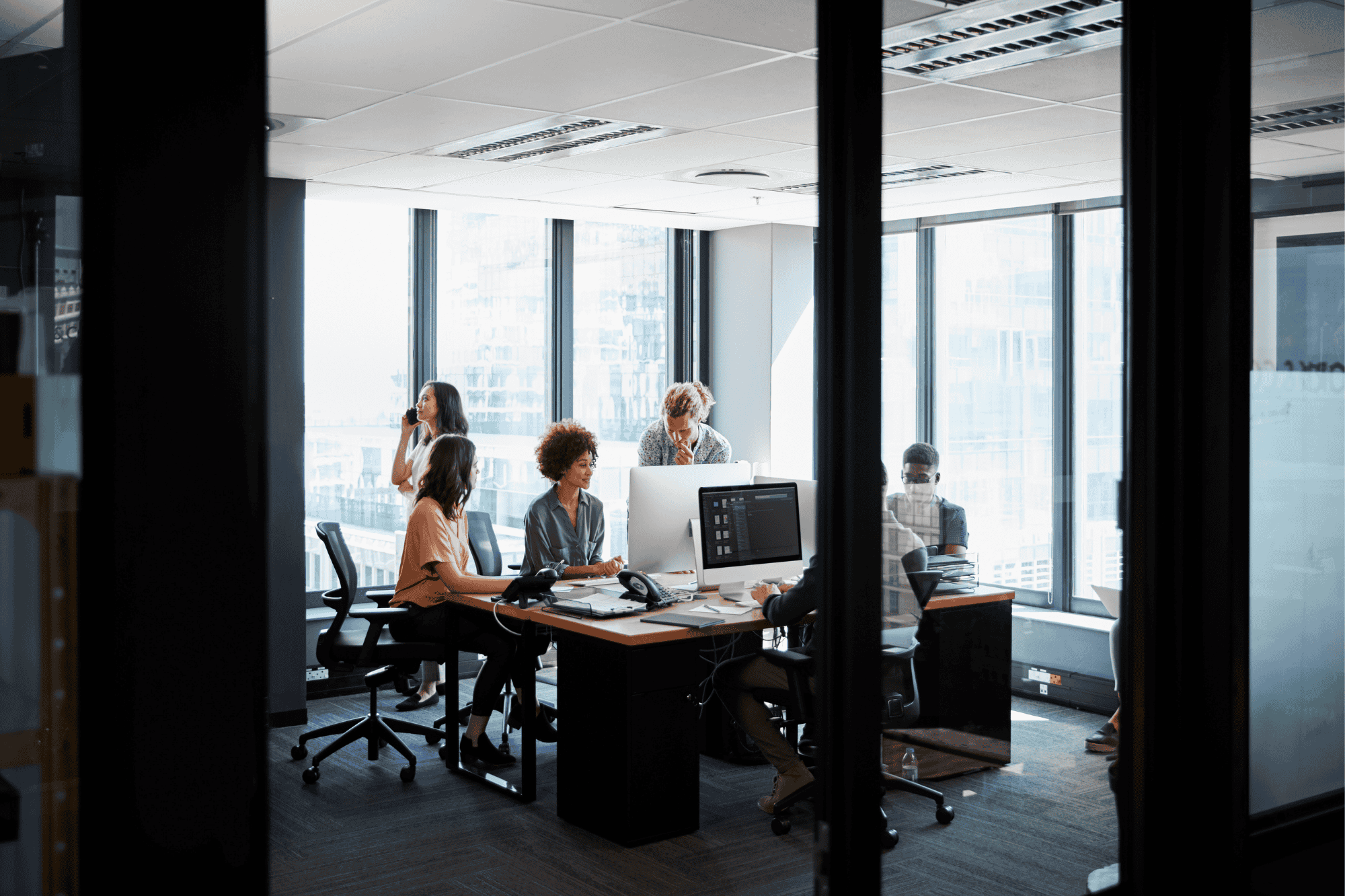 Interior of an office showing individuals collaborating at their desks