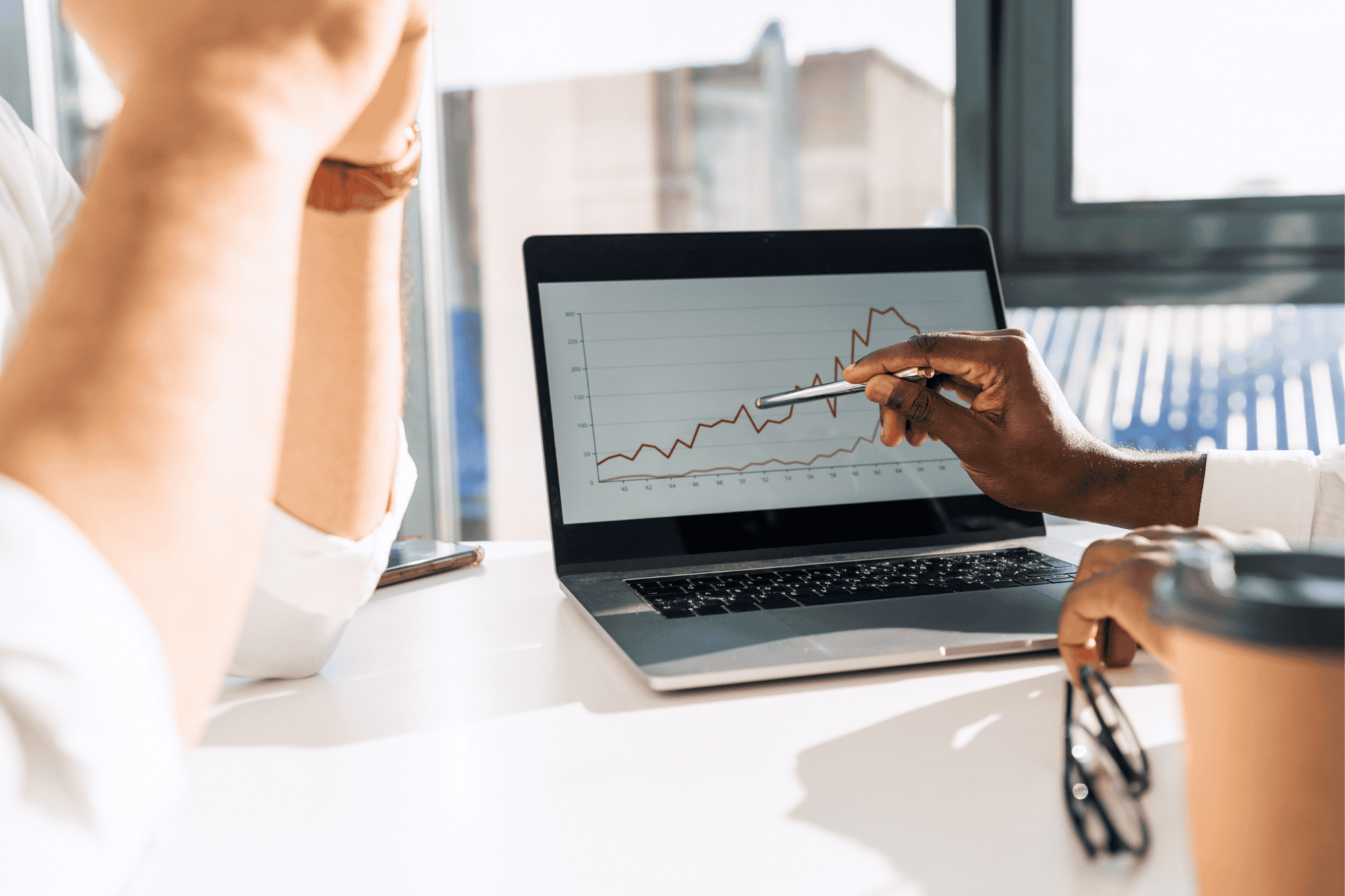 an individual pointing at laptop screen showing analytics