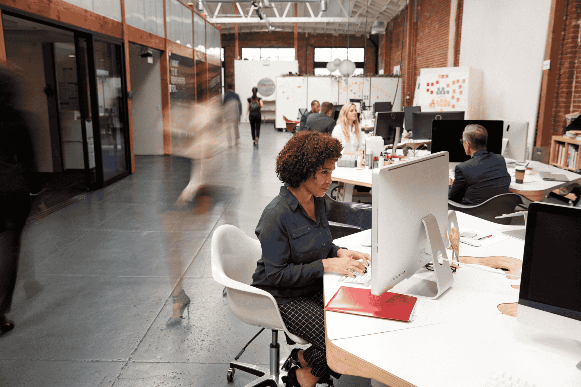 interior shot of an office with a woman typing