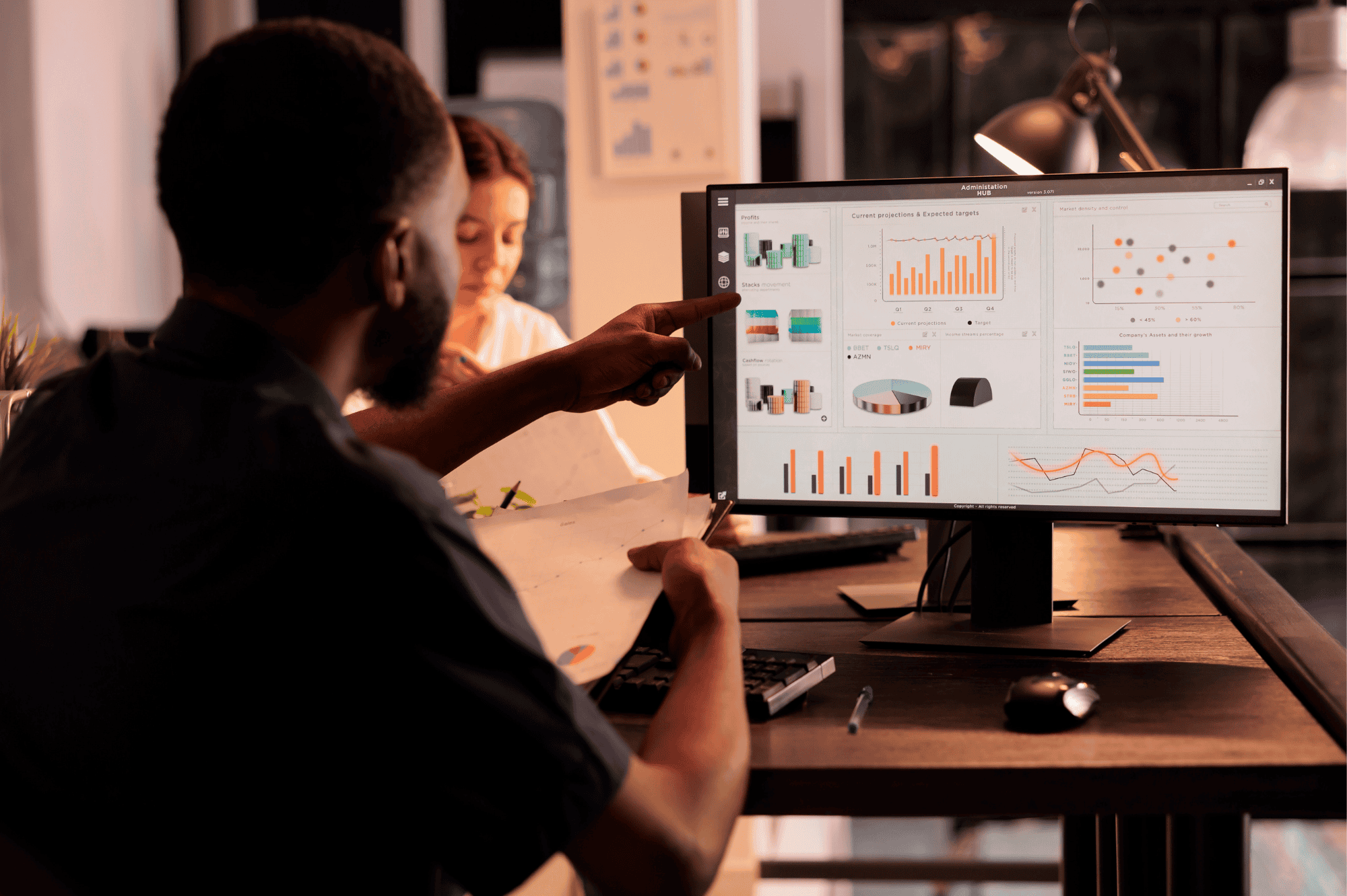 man pointing to a screen showing analytics and reporting